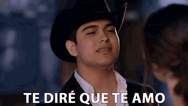 a man wearing a cowboy hat and a suit says te dire que te amo