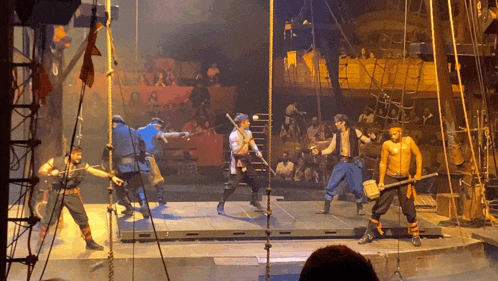 a group of men standing on a stage holding weapons