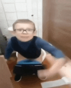 a young boy with glasses is sitting on a potty .