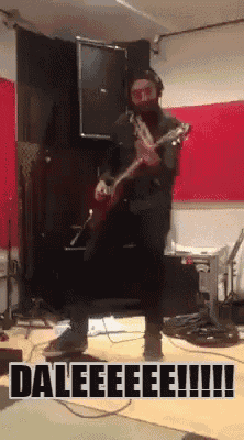 a man playing a guitar in a room with the words daleeeee !!!