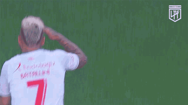 a soccer player with the number 7 on his shirt salutes