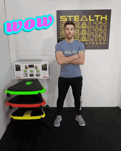 a man wearing a stealth shirt stands in front of a sign that says wow