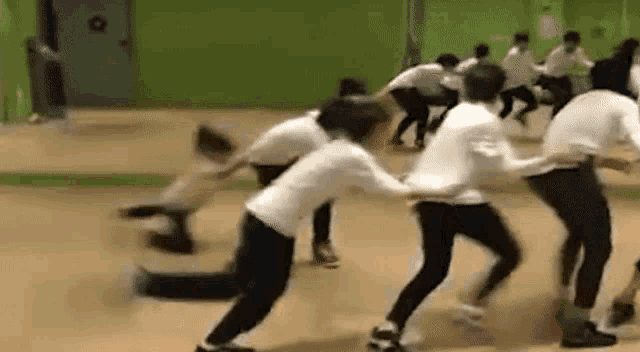 a group of people are dancing in a room .