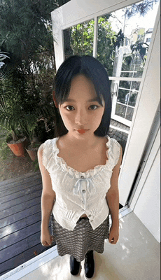 a young girl is standing in front of a door and looking at the camera