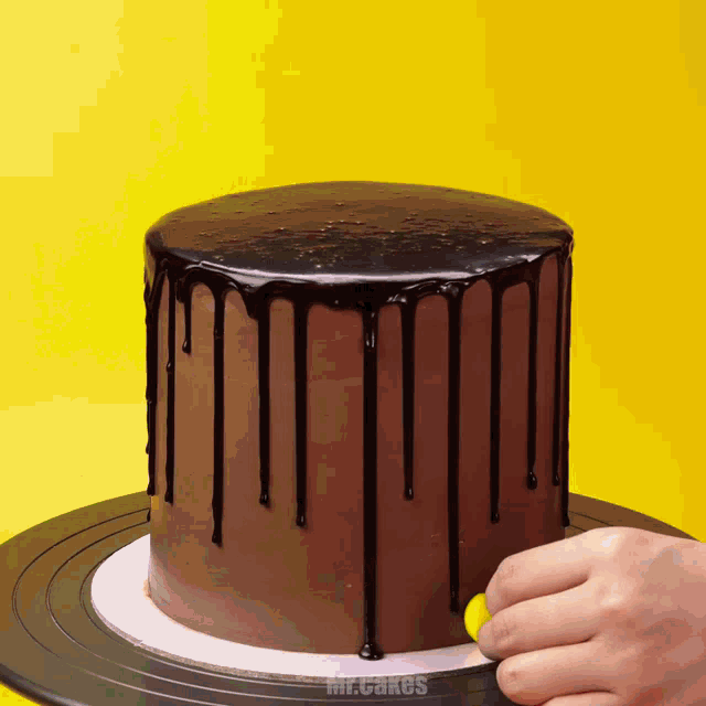a mr. cakes cake is being decorated with chocolate frosting