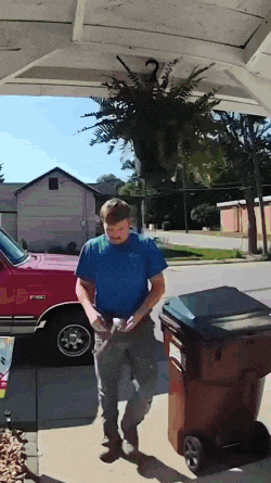 a man in a blue shirt is standing in front of a red f150