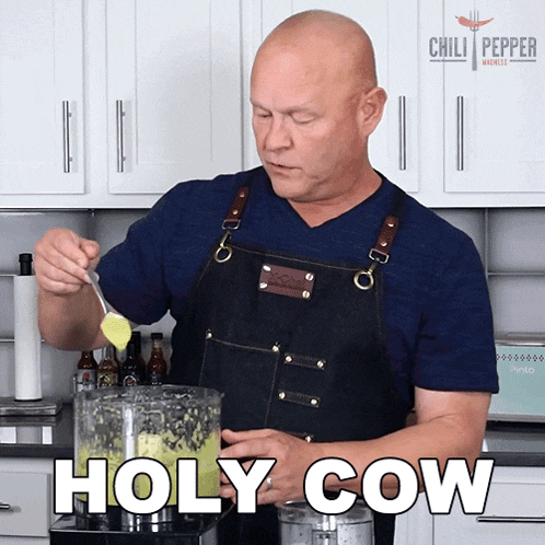 a man in an apron stirs something in a blender with the words holy cow behind him