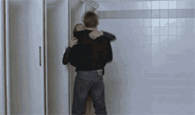 a man and woman are hugging in a bathroom .
