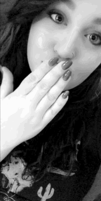 a black and white photo of a woman covering her face with her hand