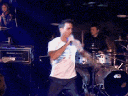 a man is singing into a microphone on a stage