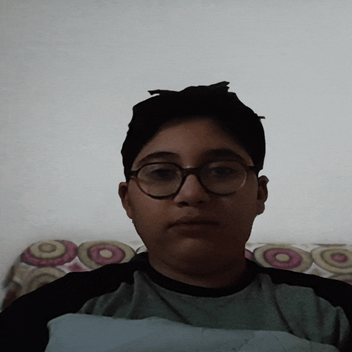 a boy wearing glasses looks at the camera