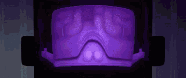 a close up of a purple object with a glowing light coming out of it .
