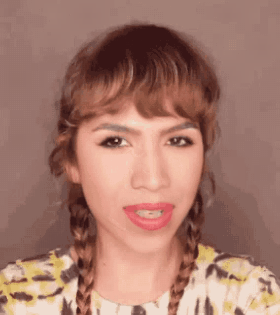 a close up of a woman 's face with braids and red lips