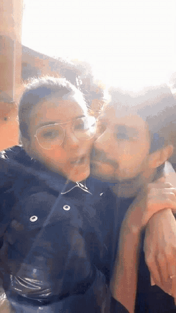 a woman is kissing a man on the cheek