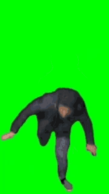 a man in a black jacket and hat is dancing in front of a green screen .