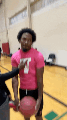 a man wearing a pink shirt with the letter w on it