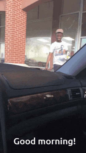 a man in a white shirt is standing in front of a car with the words good morning