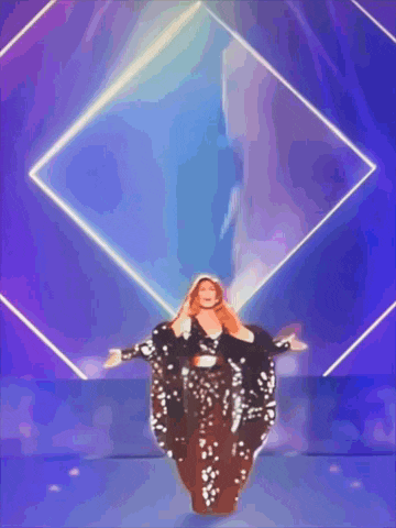 a woman in a sequined dress is dancing in front of a purple square