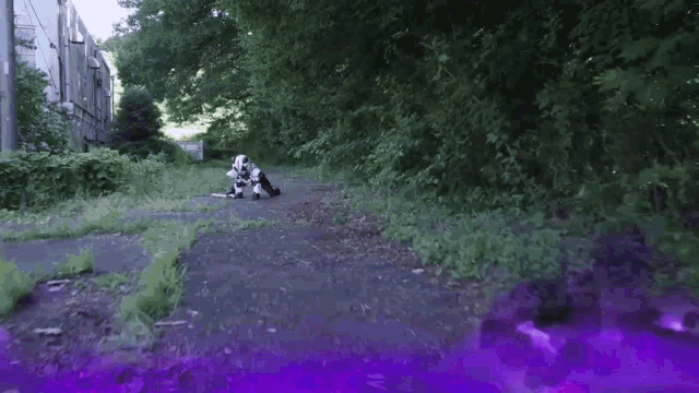 a person in a robot costume is kneeling down in a field with a purple background .