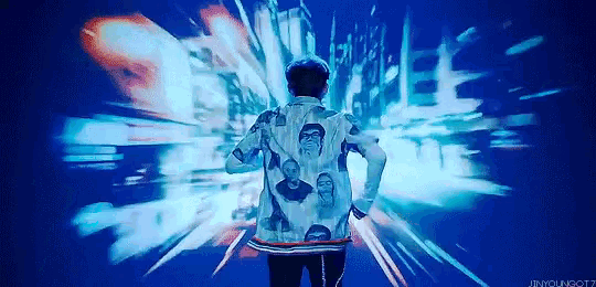 a man wearing a jacket with a picture of a man on it stands in front of a blue background .