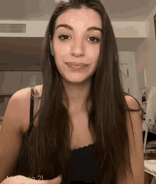 a woman with long brown hair is smiling and looking at the camera .