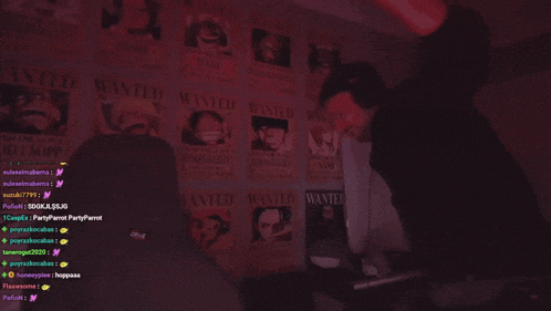 a man is standing in front of a wall with wanted posters on it