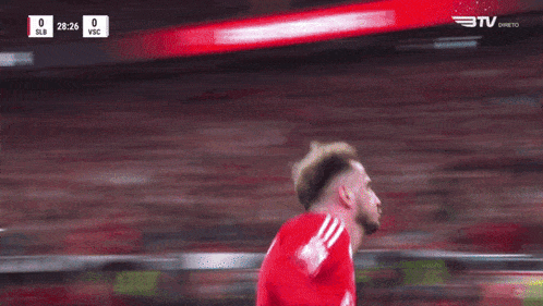 a soccer player celebrates a goal in front of a banner that says muito mais do que equa