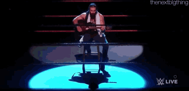 a man is playing a guitar in a wrestling ring and the name elias is on the screen