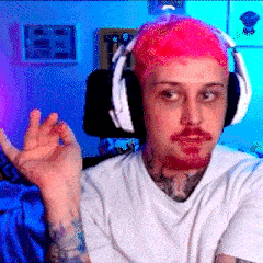 a man with pink hair and a beard is wearing headphones and making a peace sign .
