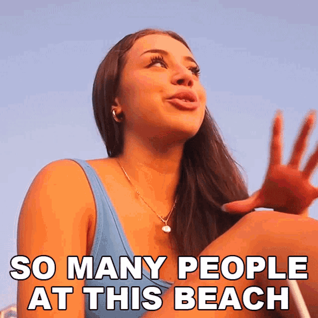 a woman sitting on a beach with the words " so many people at this beach " above her