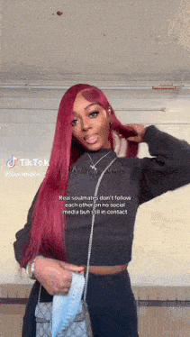 a woman with red hair is wearing a black sweater and a purse