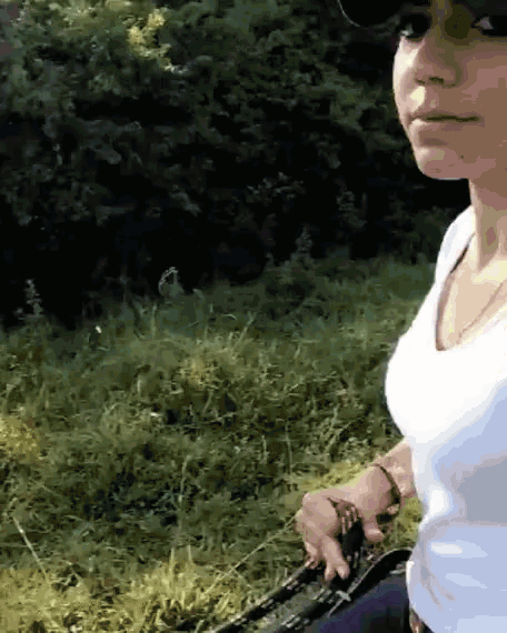 a woman in a white shirt is holding a leash
