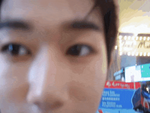 a blurry picture of a person 's face with a sign in the background that says ' a '