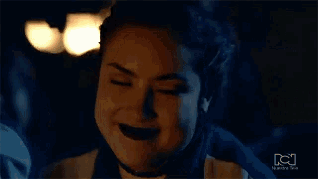 a close up of a woman making a funny face in the dark