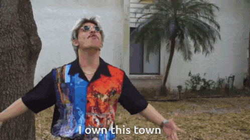 a man wearing sunglasses and a shirt that says i own this town