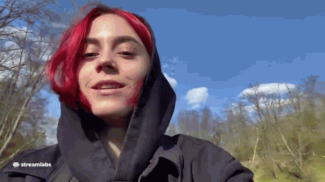 a woman with red hair wearing a black hoodie