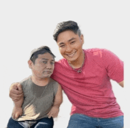 a man in a pink shirt is posing for a picture with a smaller man