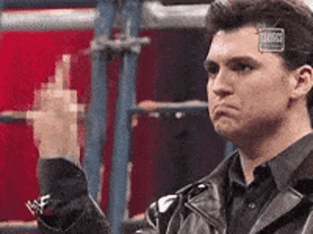 a man wearing a leather jacket is giving the middle finger
