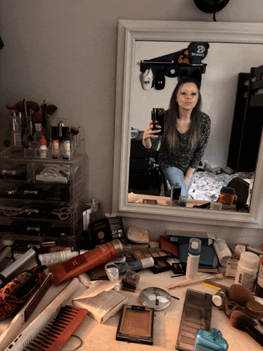 a woman is taking a selfie in front of a mirror with a sticker on the wall that says 10