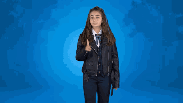 a girl wearing a leather jacket is giving a thumbs up sign