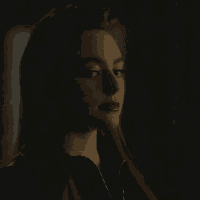a close up of a woman 's face with a dark background .