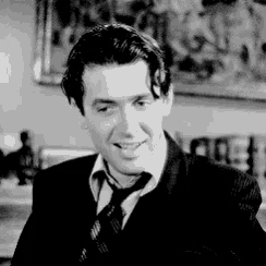 a man in a suit and tie smiles in a black and white photo