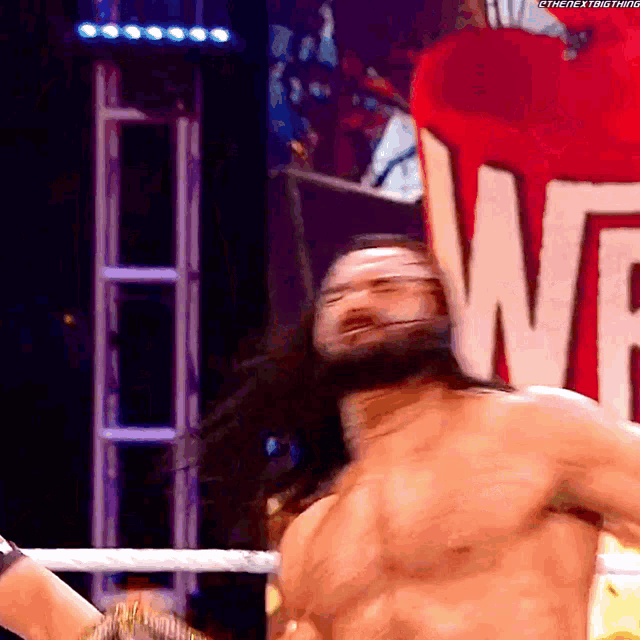 a shirtless wrestler is standing in front of a sign that says wf