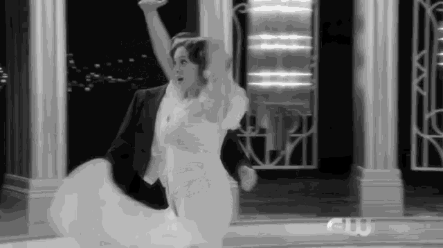 a man and a woman are dancing in a black and white photo .