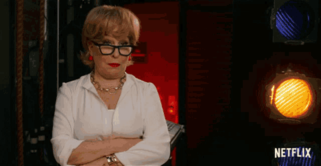 a woman with her arms crossed stands in front of a netflix logo