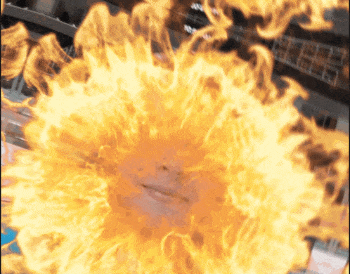 a woman 's face is surrounded by flames that look like a sun