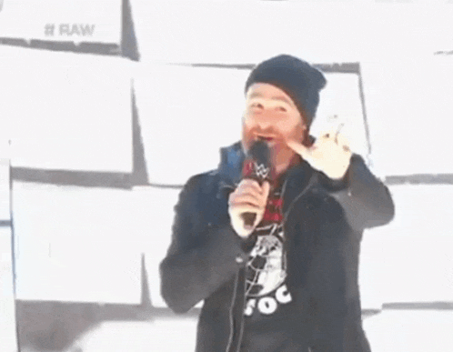 a man holding a microphone in front of a #raw sign