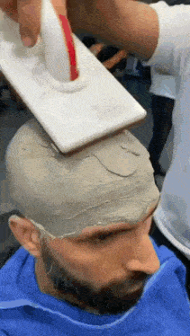 a man with a beard is getting his hair dyed