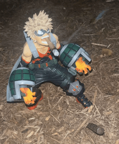 a figurine of bakugo from my hero academia is standing in the dirt