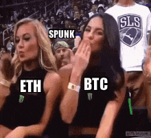 a group of women sitting in a stadium wearing shirts that say eth and btc